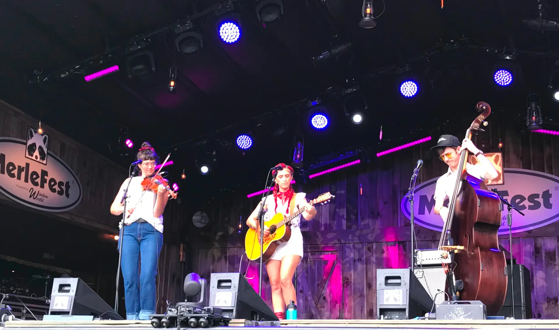 Sierra Ferrell playing guitar between a fiddler and an upright bass player at MerleFest in 2021.