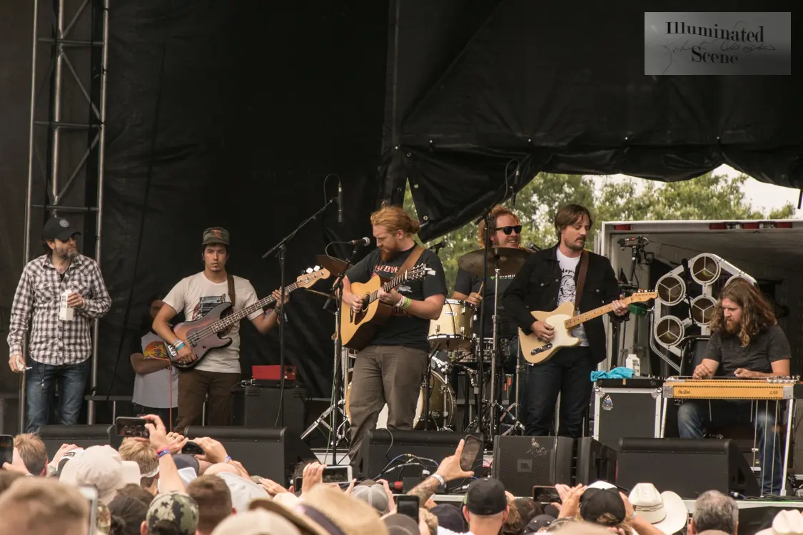 Tyler Childers playing acoustic guitar with his band at the 2018 Hinterland Music Festival.